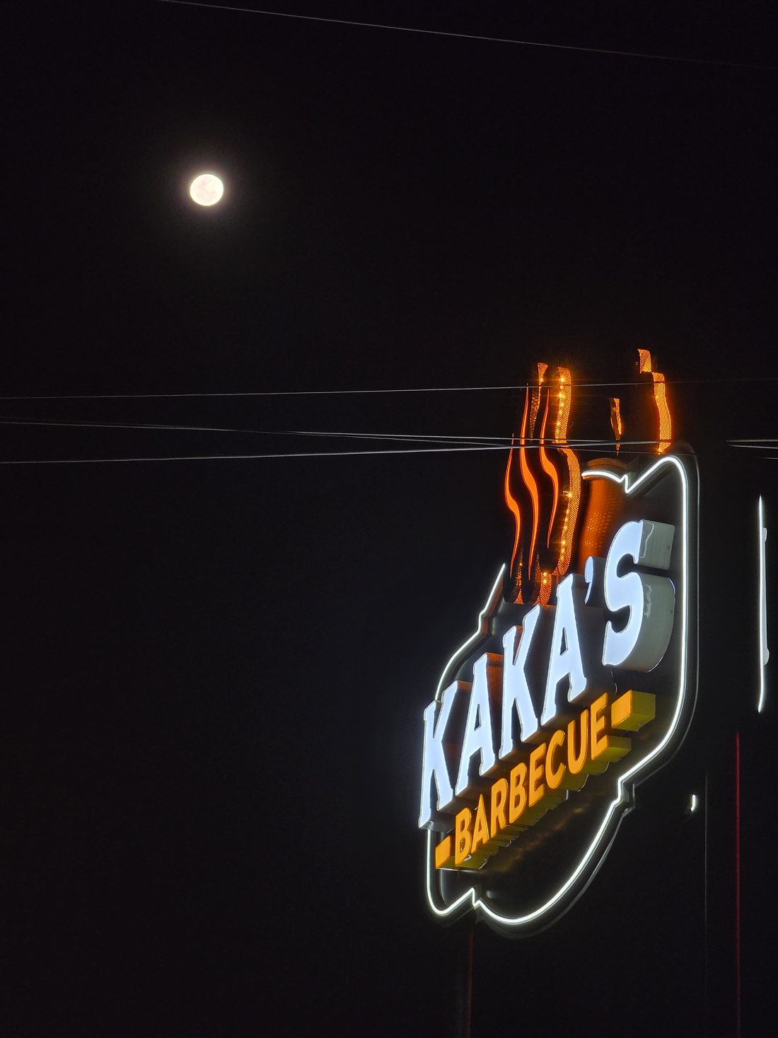 Storefront signage glowing under the moon